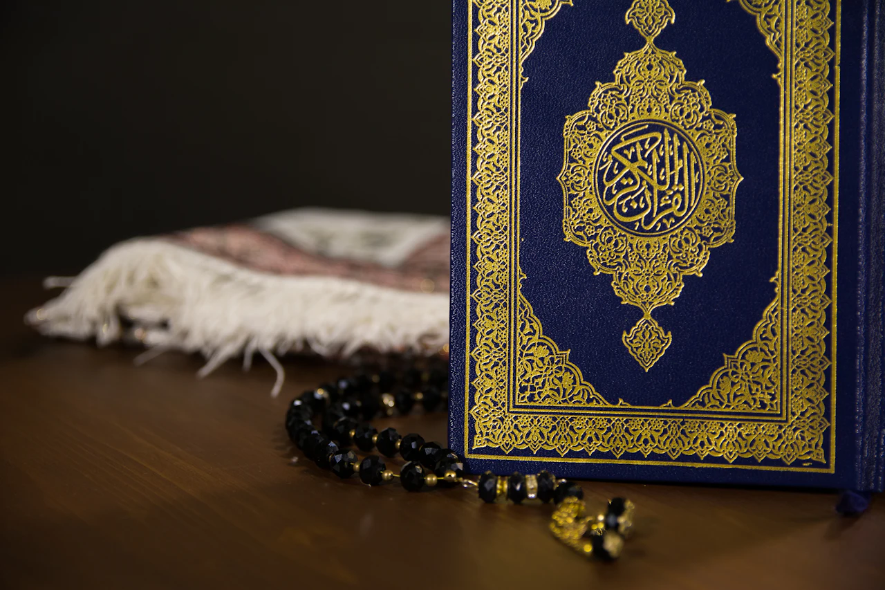 A Quran with a gold cover and prayer beads