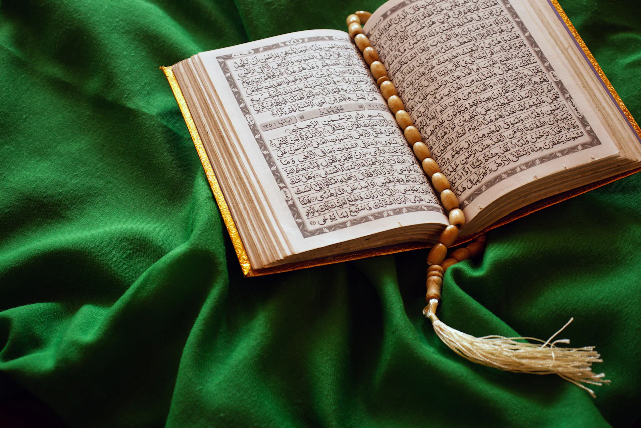 An open Quran with prayer beads